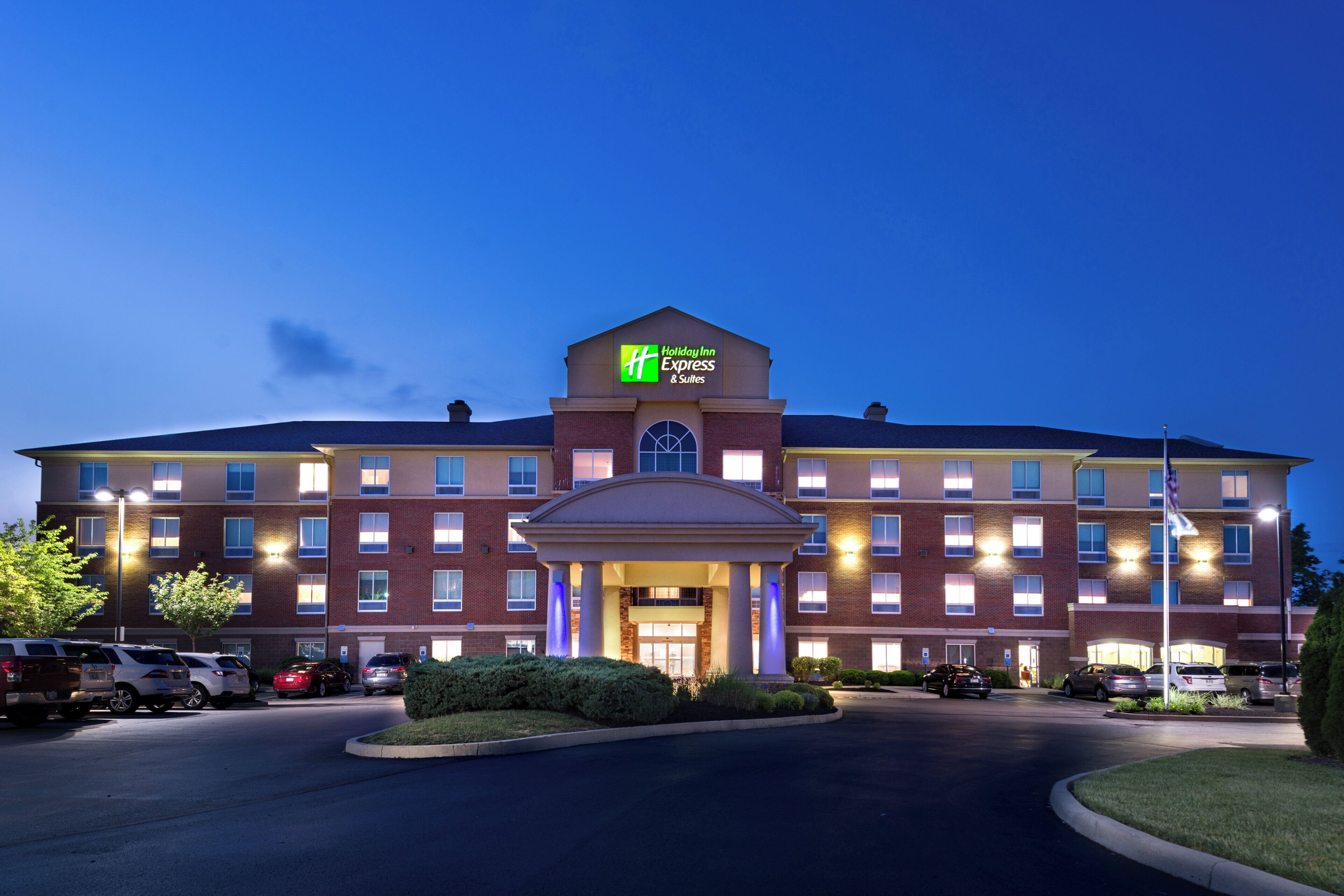 A Holiday Inn Express & Suites hotel with a brick facade, multiple windows, and a central entrance.
