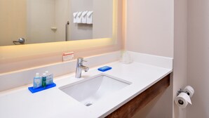 A bathroom with a white sink, a mirror, a towel rack, and a shower area. - Holiday Inn Express & Suites Cincinnati - Mason by IHG (Mason)
