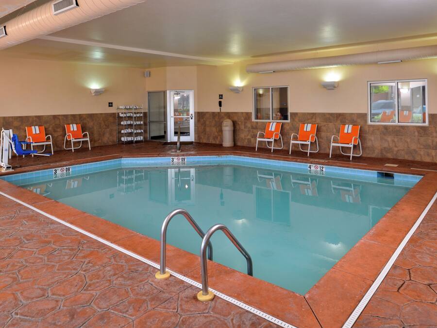 An indoor swimming pool with clear lane markings, a changing room, and a door leading to an adjacent area.