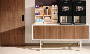 Una cocina moderna con un armario de madera, una cafetera y un hervidor.
