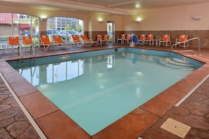 An indoor swimming pool with clear water, surrounded by lounge chairs and a stone-tiled floor. - Holiday Inn Express & Suites Cincinnati - Mason by IHG (Mason)