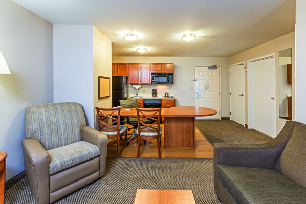A compact living space with a kitchenette, a dining area, and seating. - Candlewood Suites Owasso by IHG (Owasso)