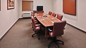 A conference room with a long table, leather chairs, a television, and a cabinet. - Candlewood Suites Owasso by IHG (Owasso)
