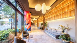 A modern lobby with a reception desk, seating area, and large windows overlooking a street. - Canal City Fukuoka Washington Hotel (Fukuoka)