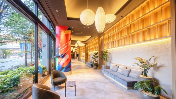 A modern lobby with a reception desk, seating area, and large windows overlooking a street. - Canal City Fukuoka Washington Hotel (Fukuoka)