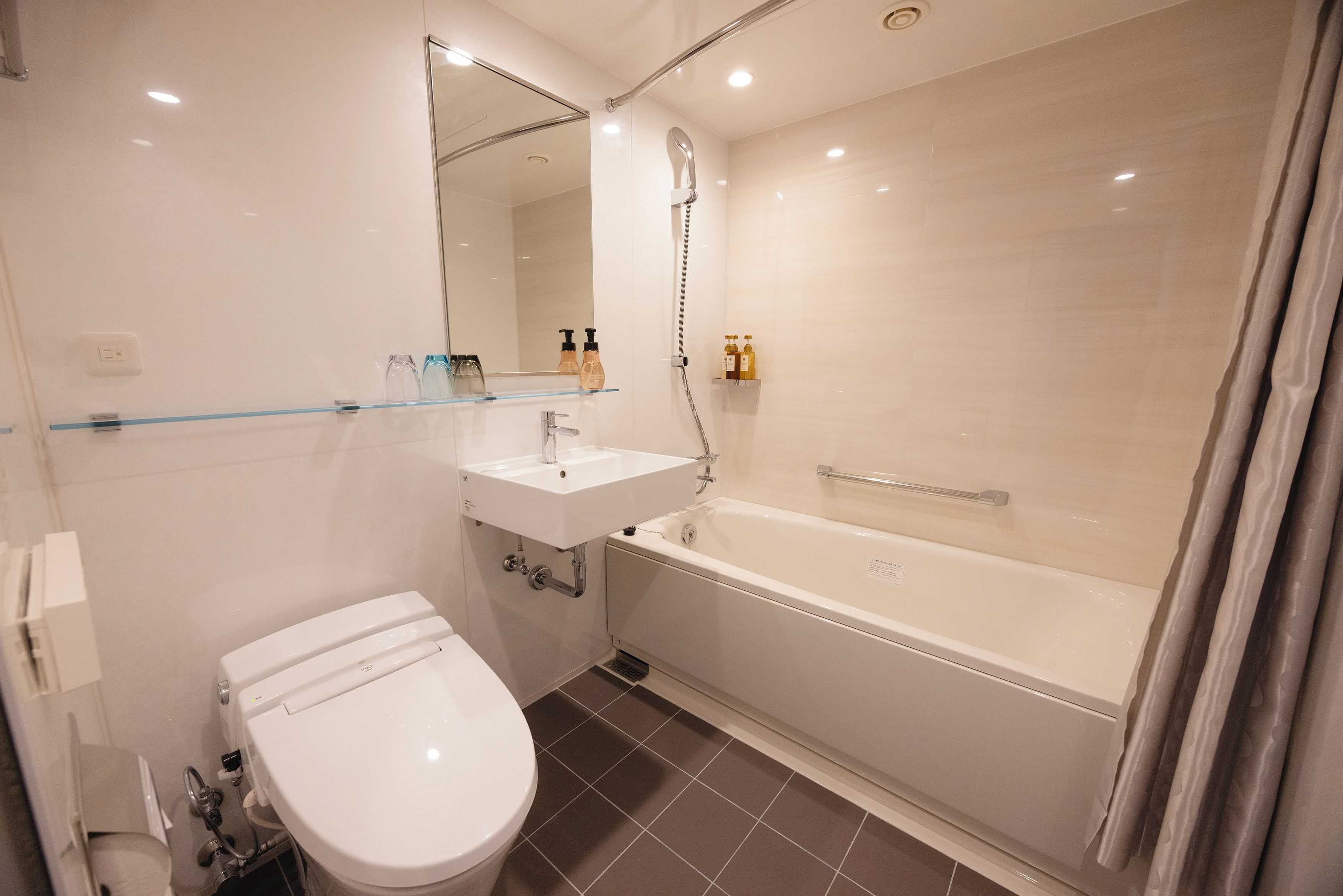 Une salle de bain moderne équipée de toilettes, d’un lavabo et d’une baignoire.