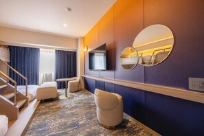 A hotel room with a flat-screen TV, a round mirror, a sofa, a small table, and a carpeted floor. - Canal City Fukuoka Washington Hotel (Fukuoka)
