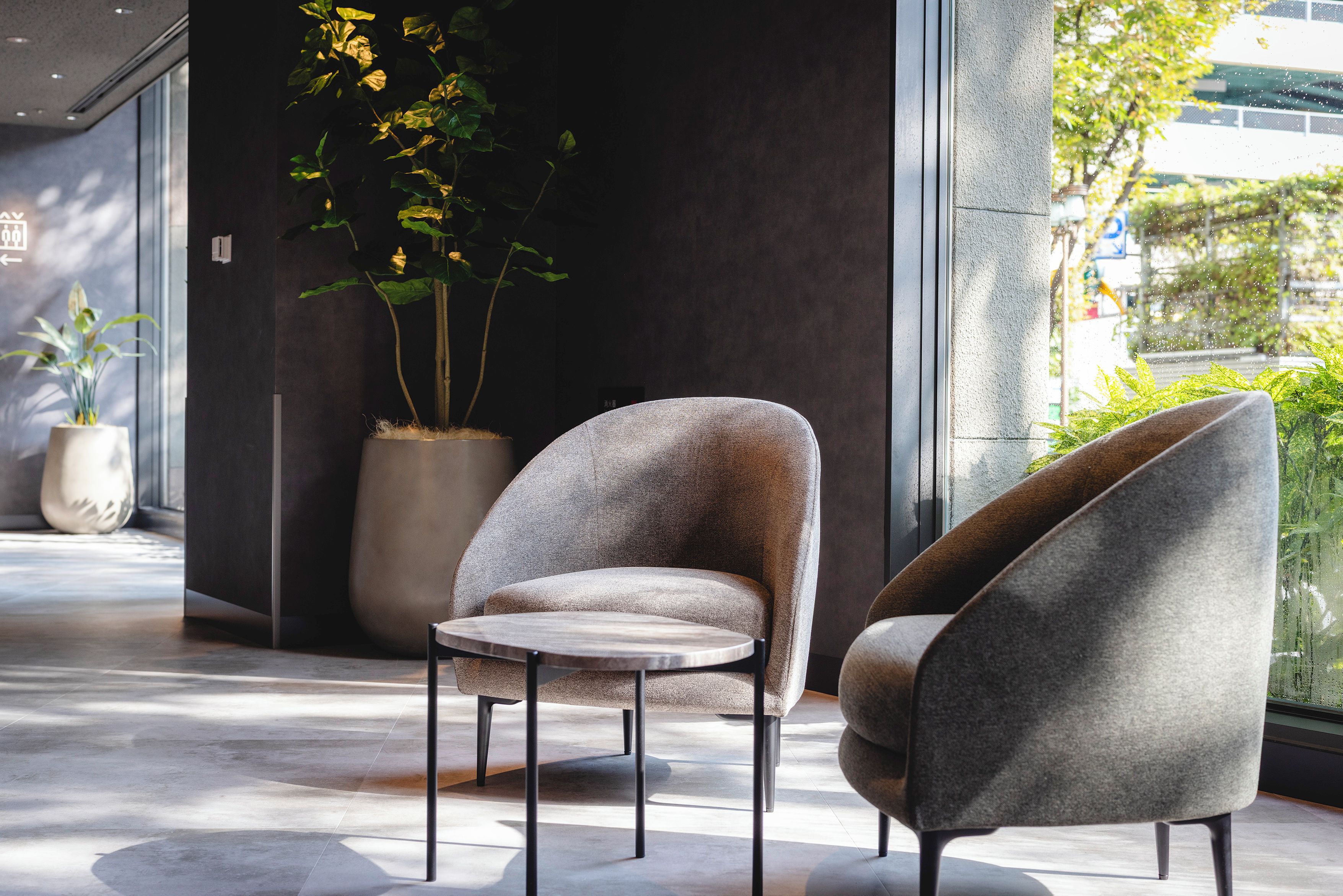 A modern interior with a seating area featuring two armchairs and a small round table.