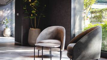 A modern interior with a seating area featuring two armchairs and a small round table.