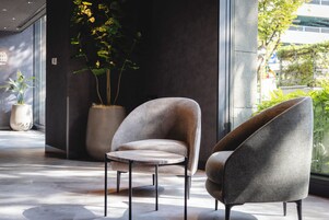 A modern interior with a seating area featuring two armchairs and a small round table.