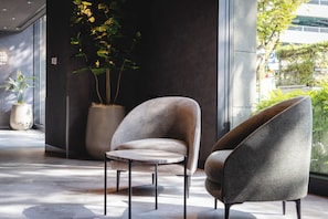 A modern interior with a seating area featuring two armchairs and a small round table.