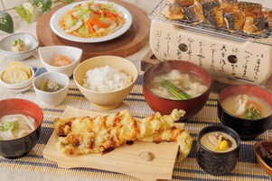 A variety of Japanese dishes including sushi, tempura, and a bowl of soup.