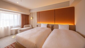 A hotel room with two beds, a small round table, a sofa, and a large window with curtains. - Canal City Fukuoka Washington Hotel (Fukuoka)
