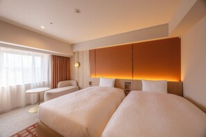A hotel room with two beds, a small round table, a sofa, and a large window with curtains. - Canal City Fukuoka Washington Hotel (Fukuoka)