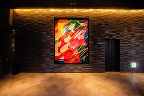 A modern interior with a large abstract painting on a textured wall, a dark elevator, and a polished floor. - Canal City Fukuoka Washington Hotel (Fukuoka)
