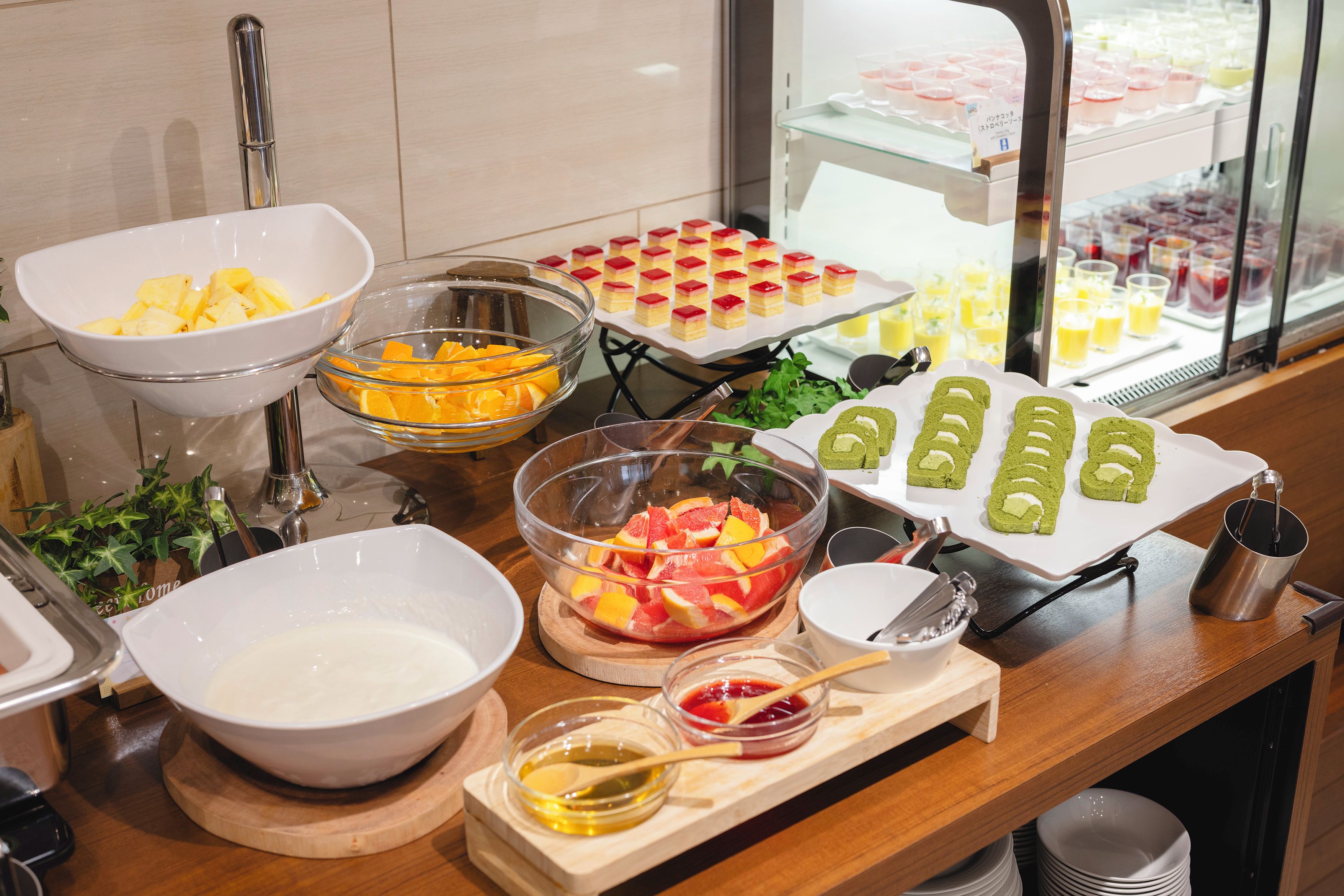 Un buffet proposant une variété d’aliments, notamment des fruits, des desserts et des boissons.