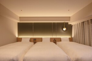 Habitación de hotel con dos camas, un panel de pared grande, una lámpara colgante y una cortina.