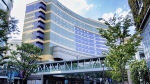 A modern hotel with a curved facade, multiple balconies, and a pedestrian bridge. - Canal City Fukuoka Washington Hotel (Fukuoka)