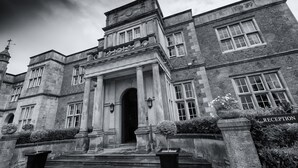 A historic building with a grand entrance, columns, and a reception sign.