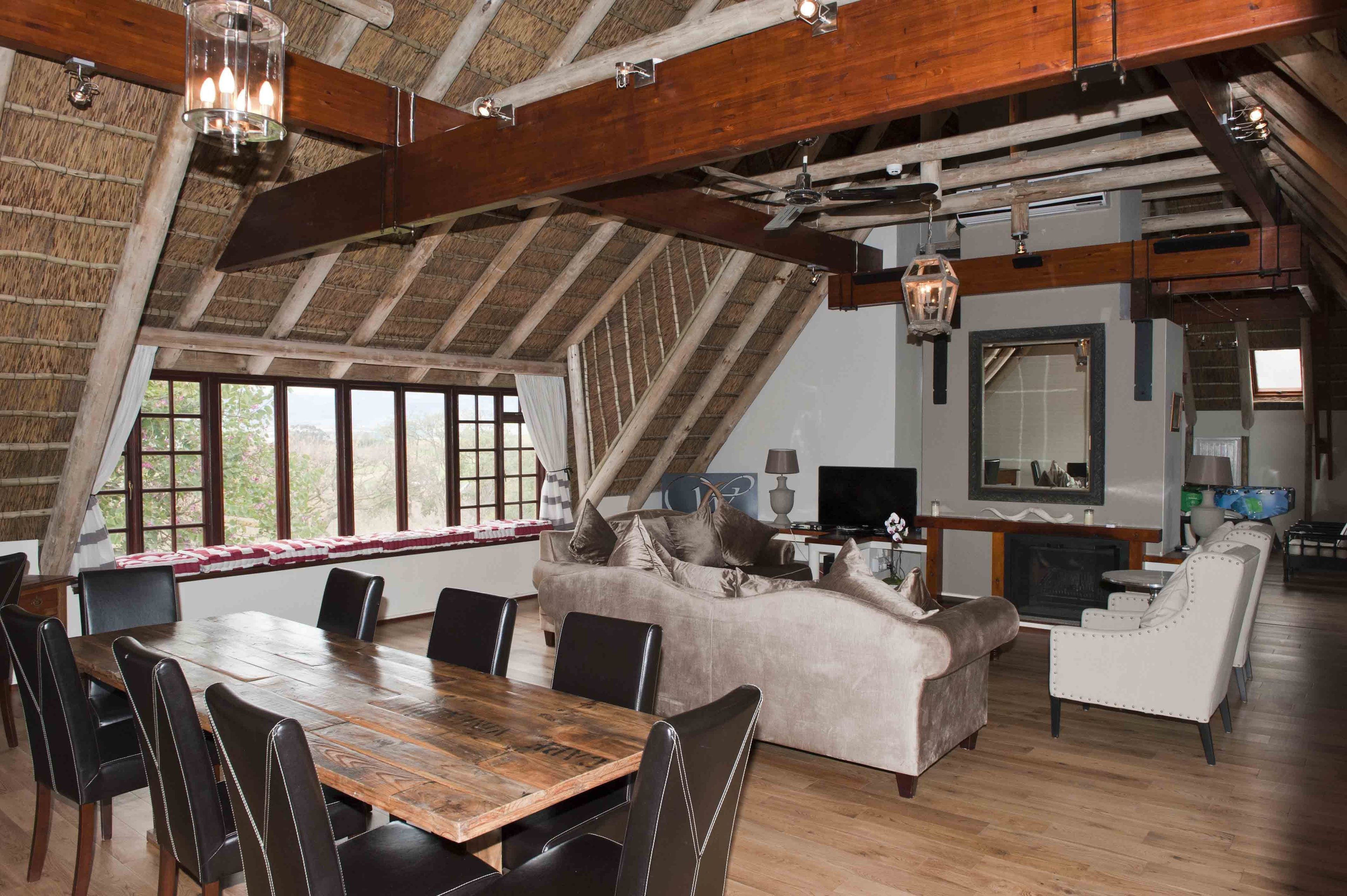 A spacious loft-style living area with a large dining table, comfortable seating, and a fireplace.