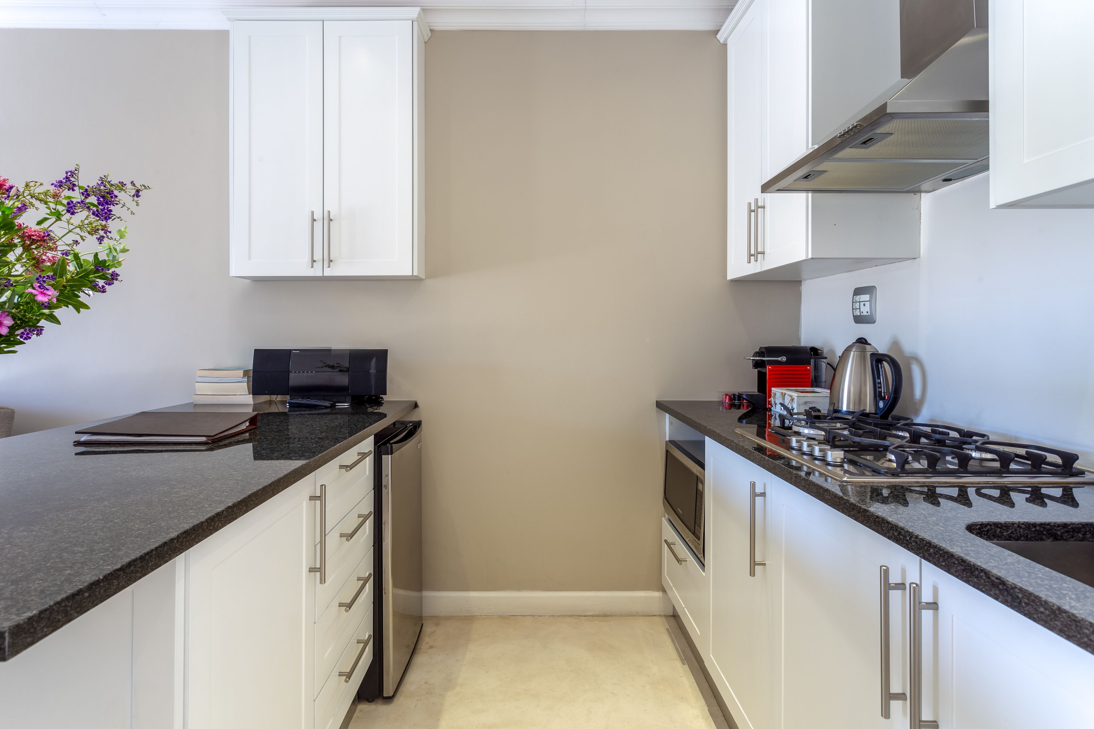 A modern kitchen with white cabinets, a gas stove, and a microwave.