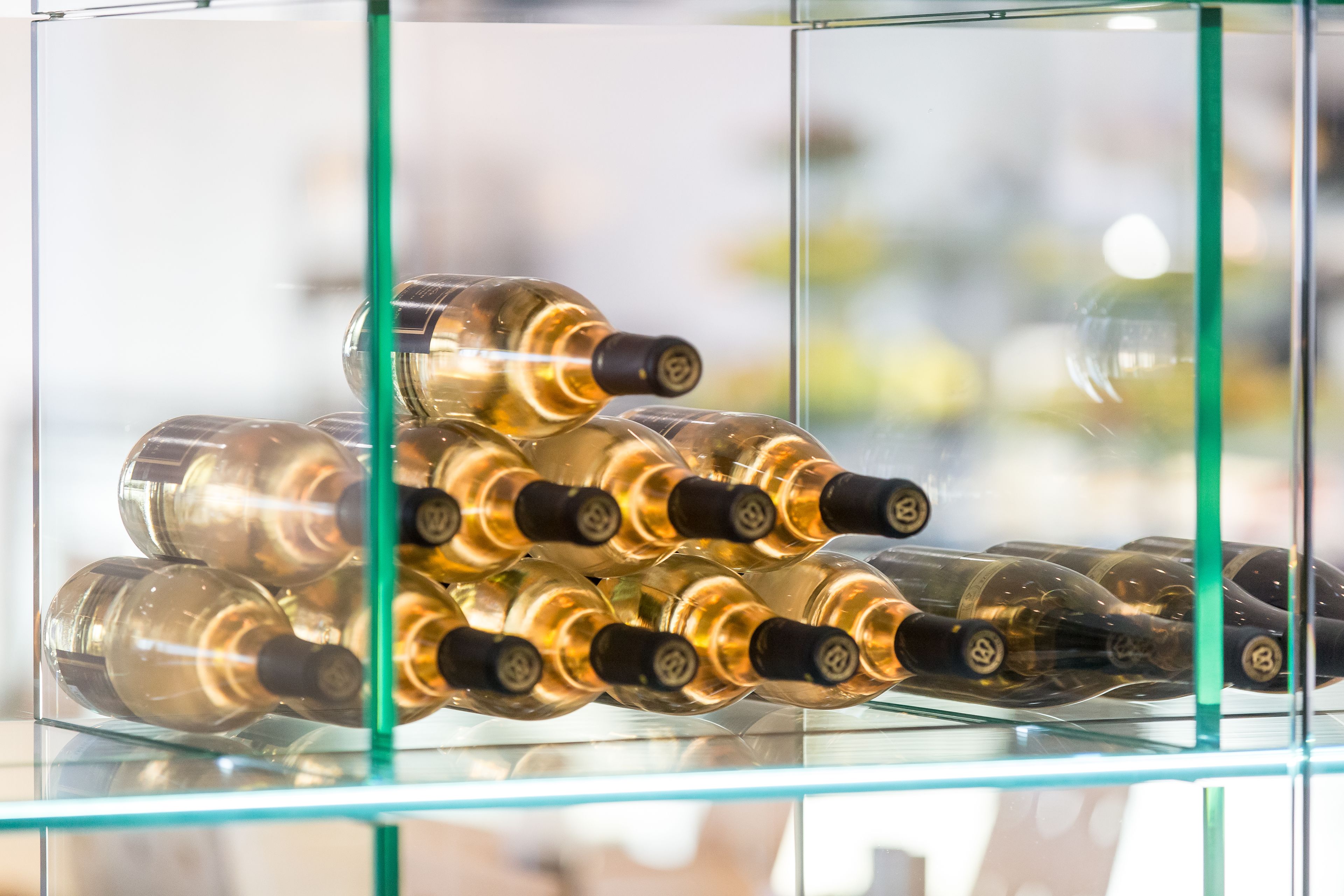 A display of wine bottles in a glass case.
