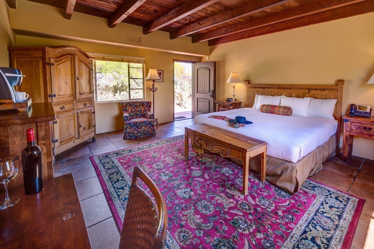 Une chambre à coucher comprenant un lit, une tête de lit en bois, une table de chevet, une lampe et une chaise.