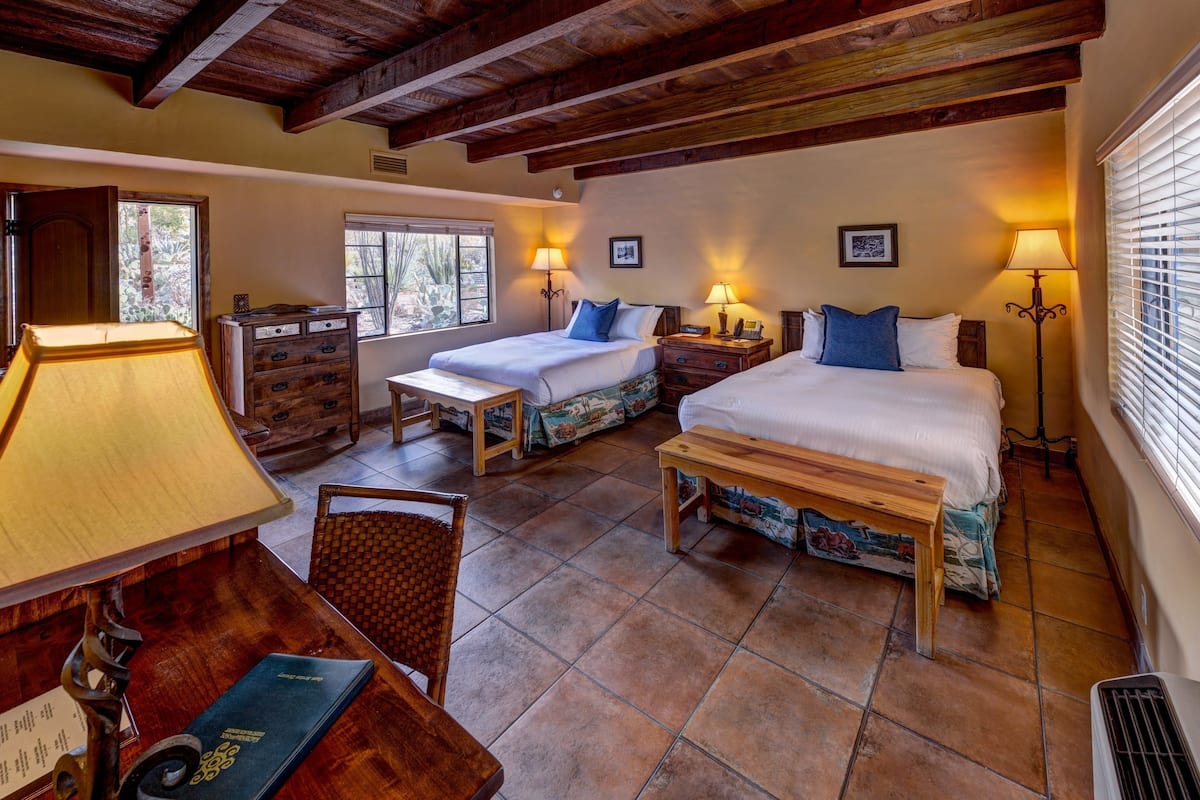 Une chambre confortable avec deux lits, des meubles en bois et un plafond rustique.