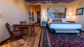 A bedroom with a bed, bedside tables, a desk, and a chair.
