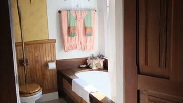 A bathroom with a wooden vanity, a white toilet, and a bathtub.
