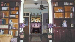 Una sala de estar acogedora con chimenea, estanterías y elementos decorativos.