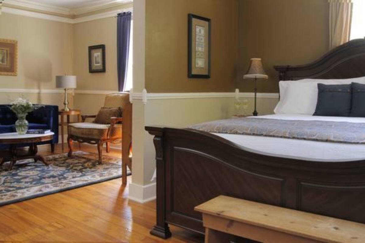 Een hotelkamer met een groot bed, een klein tafeltje, een stoel en een bank.