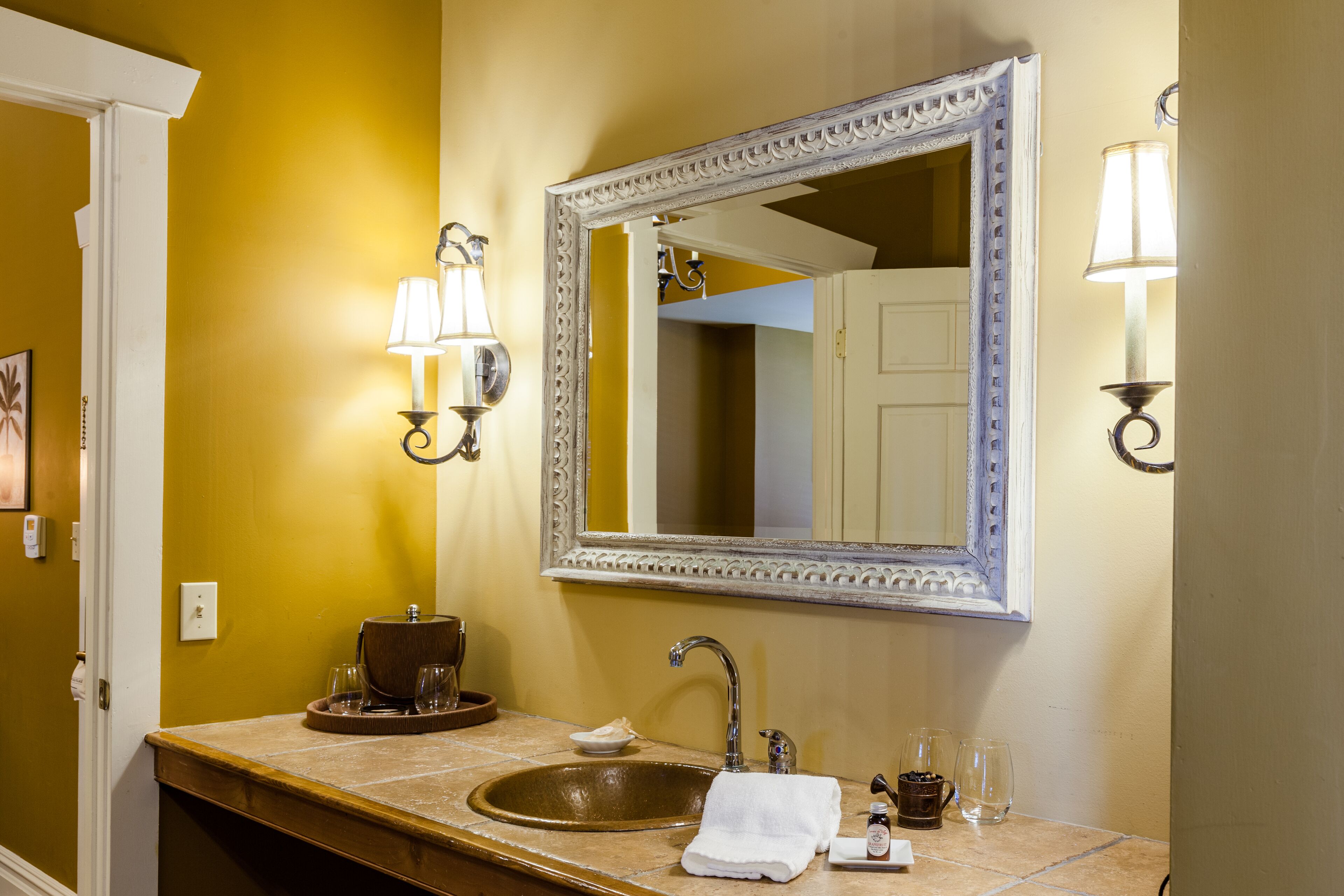 A bathroom with a sink, mirror, and two wall-mounted lights.