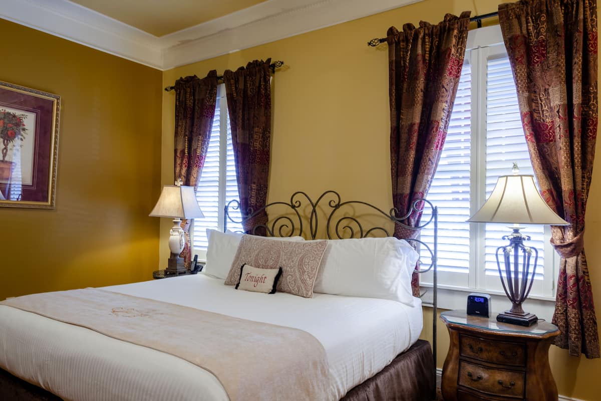 A neatly made bed with a pillow labeled "Tonight," a bedside lamp, and a nightstand with a clock.