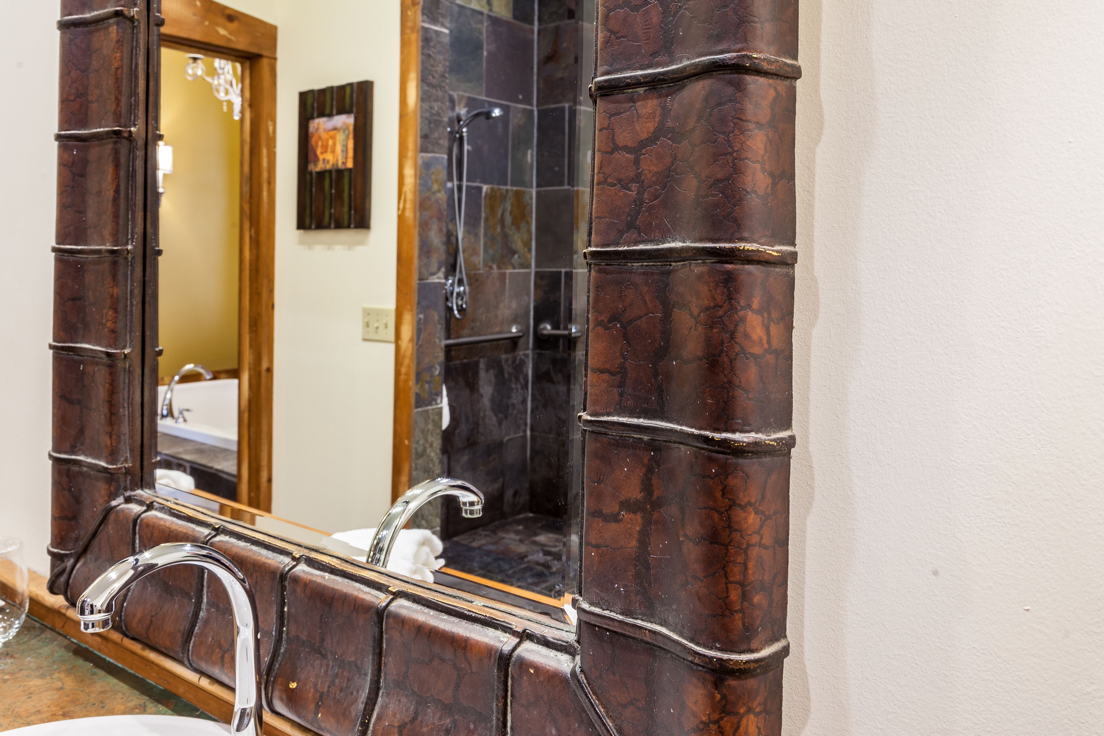 Une salle de bain avec un grand miroir, un lavabo et un espace douche.