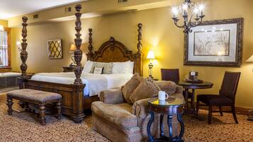 Une chambre d’hôtel avec un grand lit, un canapé, une petite table et une chaise.