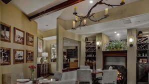 Un'accogliente sala da pranzo con un lampadario, quadri appesi alle pareti e un camino.