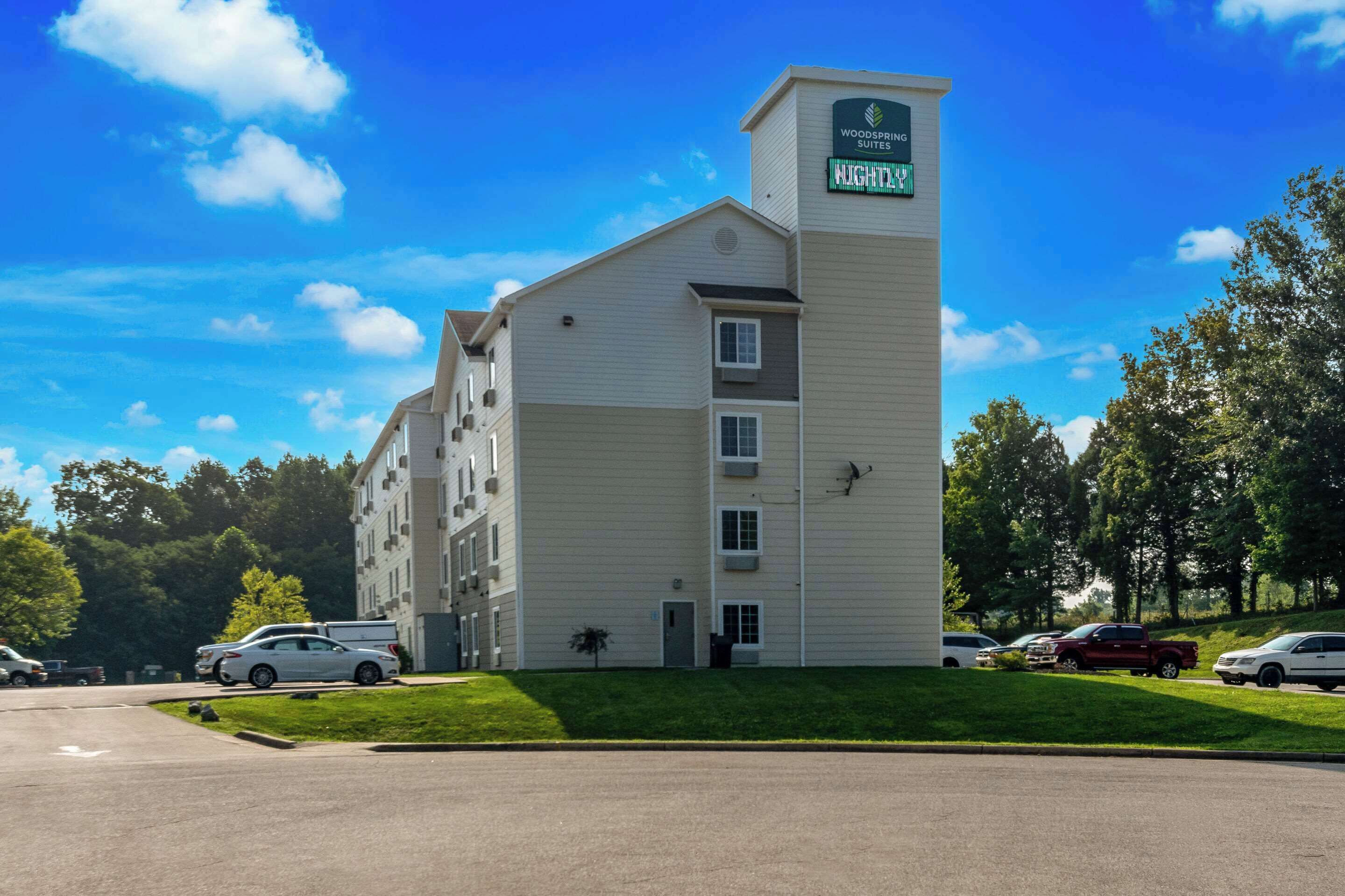 Un hotel de varios pisos con un letrero llamativo que dice "Woodspring Suites".