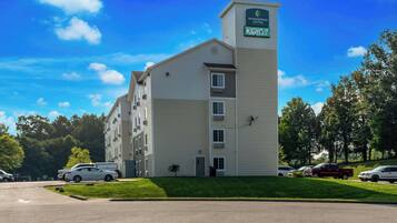 Un hotel de varios pisos con un letrero llamativo que dice "Woodspring Suites".