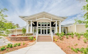 A two-story building with a covered entrance and a stone foundation.