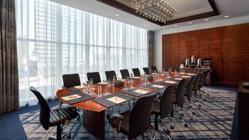 A conference room with a long table, chairs, and a chandelier.
