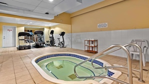 A swimming pool with a tiled deck, exercise equipment, and a sign indicating a rest area. - Coast Fraser Inn (Williams Lake)