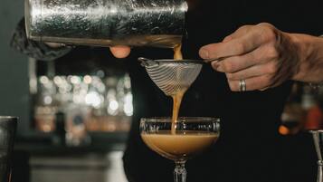 Un camarero sirviendo una bebida en un vaso.