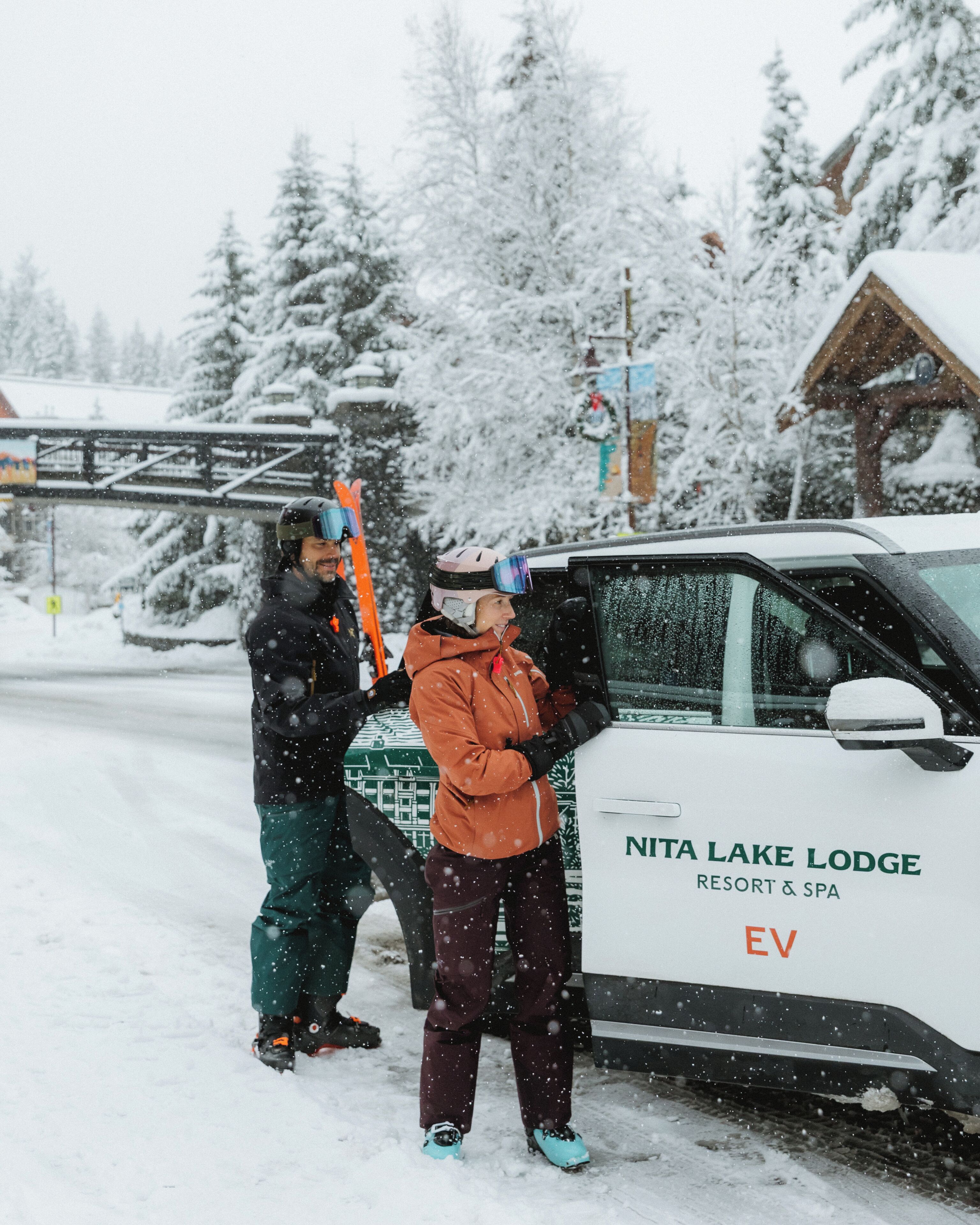 A snow-covered scene with a vehicle labeled 'NITA LAKE LODGE RESORT & SPA' and a person standing next to it.