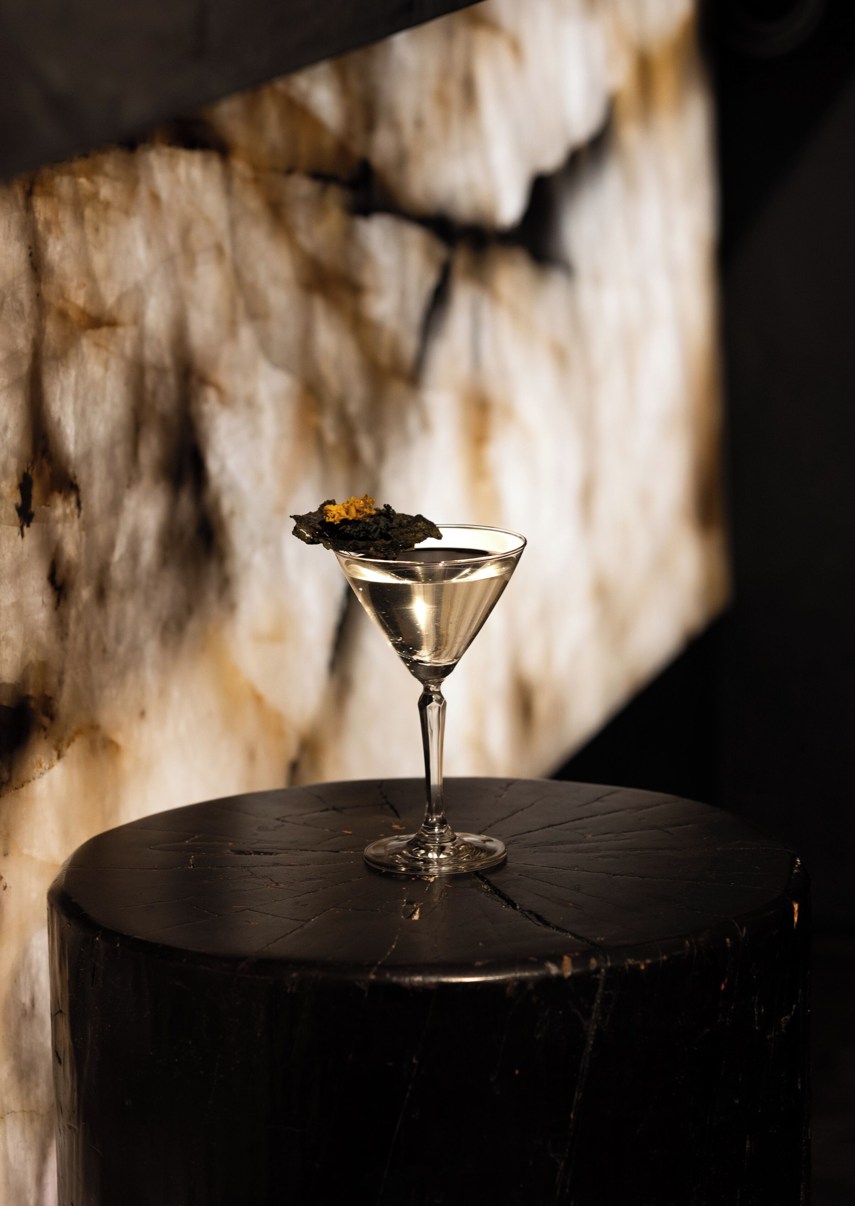 Una copa de martini sobre un taburete de madera.
