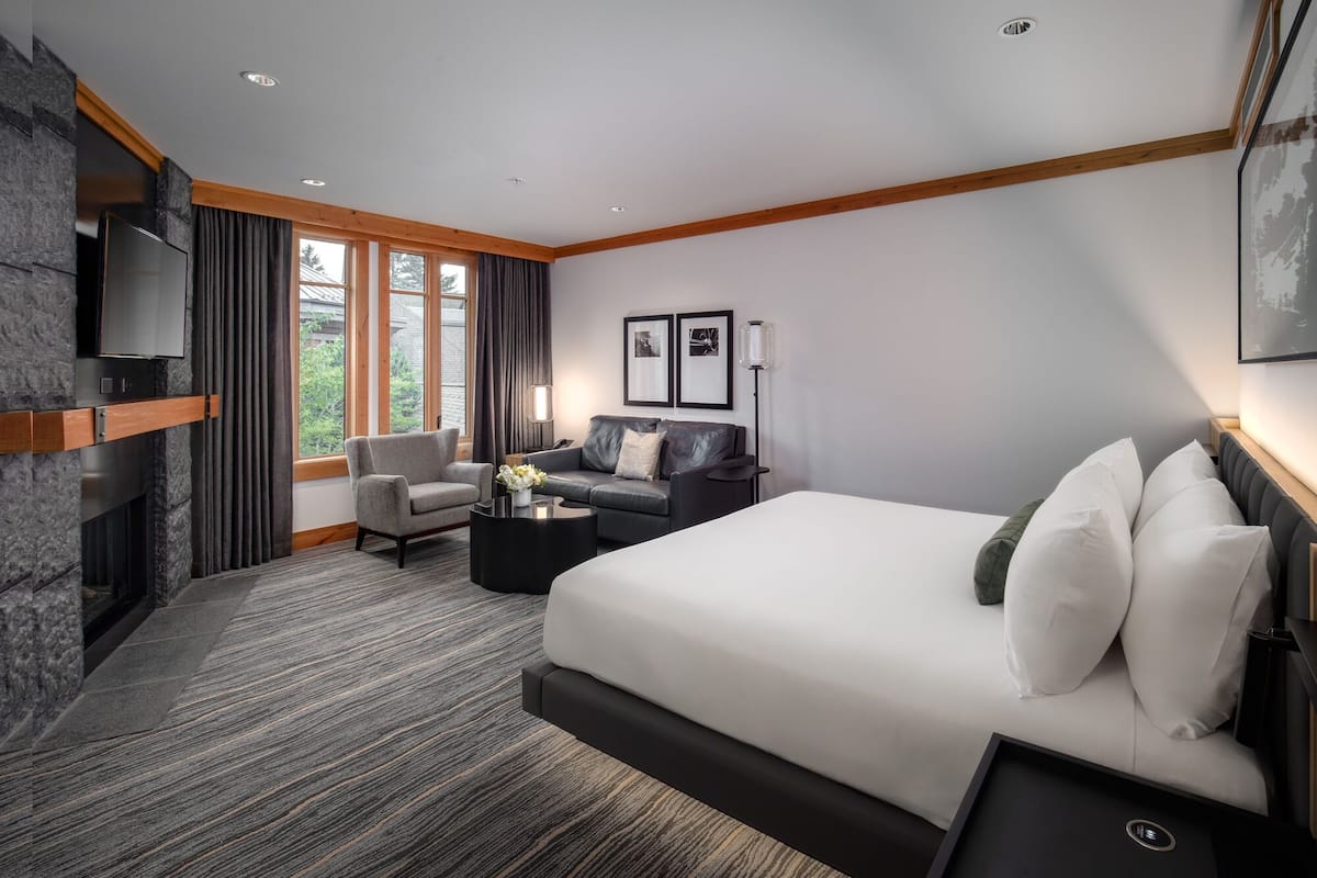 Een moderne hotelkamer met een groot bed, een slaapbank, een bureau en een televisie.