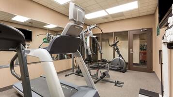 A gym with treadmills, elliptical machines, and weight equipment.