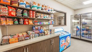Un présentoir proposant des en-cas et des glaces dans un magasin, avec divers en-cas emballés et des pots de glace.