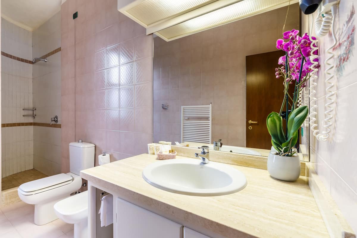 Un baño moderno con lavamanos, inodoro y ducha.
