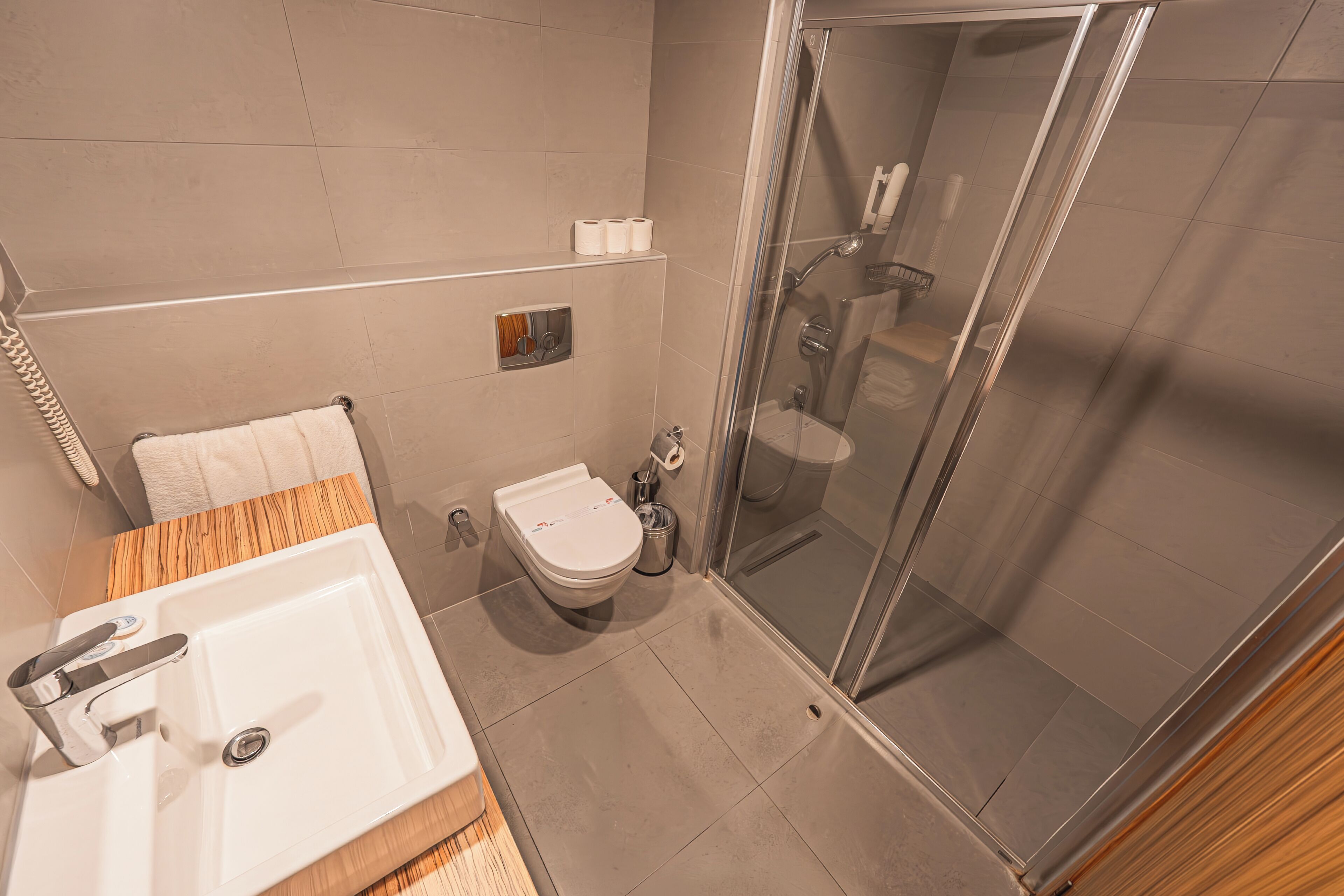 A modern bathroom with a shower, toilet, and sink.